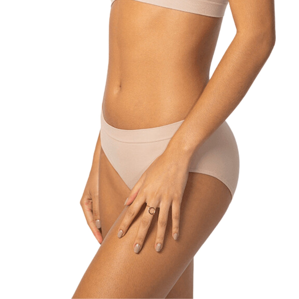 Mulher usando calcinha tanga Cygnuss, sem costura, tecido respirável, confortável e elegante, cor nude. Ideal para dia a dia.