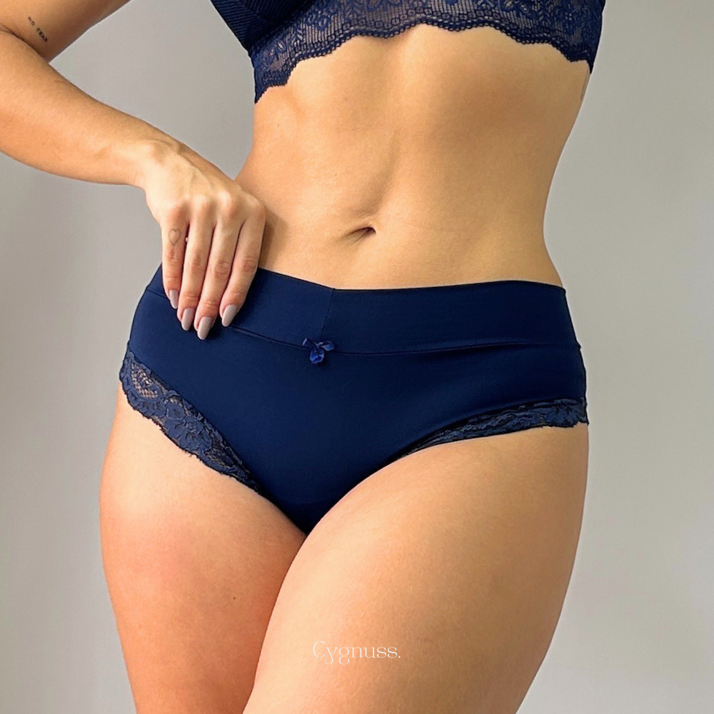 Mulher usando Calcinha Aurora com renda delicada em azul marinho da Cygnuss, esbanjando conforto e elegância.