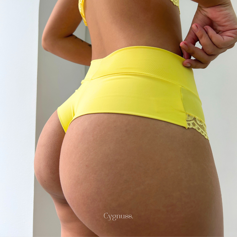 Calcinha Aurora com renda delicada em amarelo, destacando conforto e elegância para o dia a dia feminino. Marca Cygnuss.