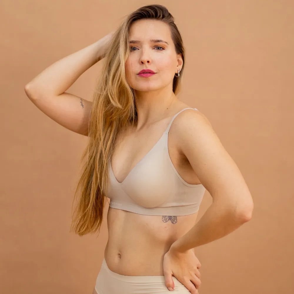 Modelo loira vestindo o Sutiã Alça Fina Cygnuss na cor nude, destacando a modelagem anatômica que realça e sustenta o busto.