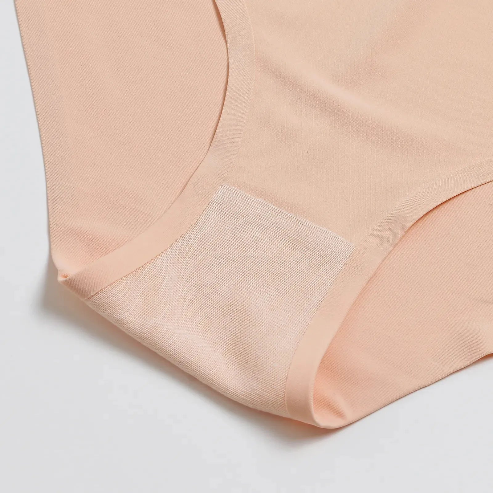 Imagem detalhada da calcinha bege da Cygnuss, focando na área da virilha com um reforço em tecido respirável. O design sem costura e a textura suave garantem conforto e proteção ao longo do dia.