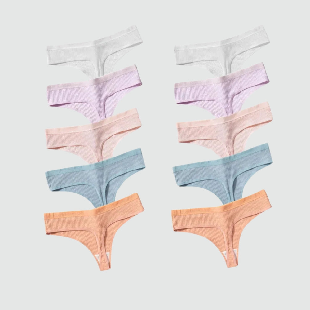 Conjunto com 10 calcinhas fio dental em tecido canelado, dispostas lado a lado em tons pastel variados: branco, lilás, rosa claro, azul bebê e terracota. As peças estão organizadas simetricamente sobre fundo cinza claro, evidenciando a variedade de cores do kit.