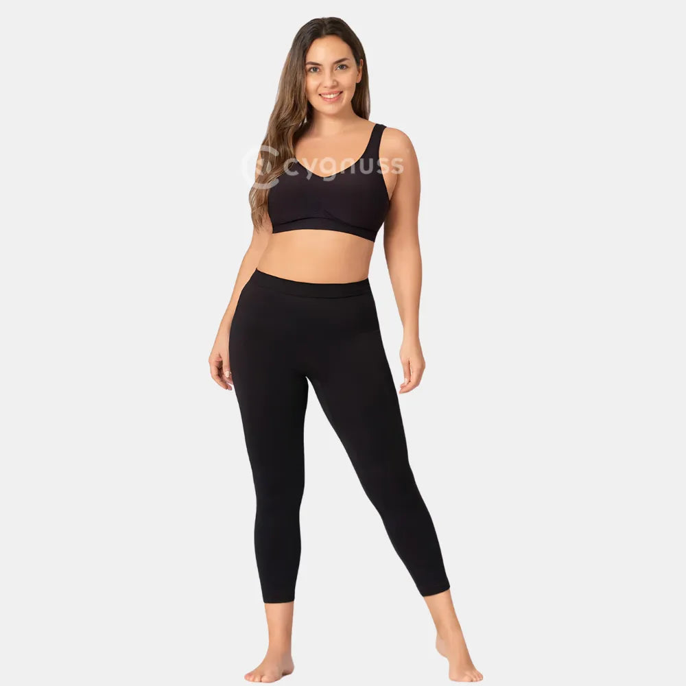 Mulher sorrindo, usando a Legging Jade Fit Modeladora de Cós Alto na cor preta, combinada com top sem aro, destacando o visual moderno, o cós anatômico e o caimento ajustado até o tornozelo.