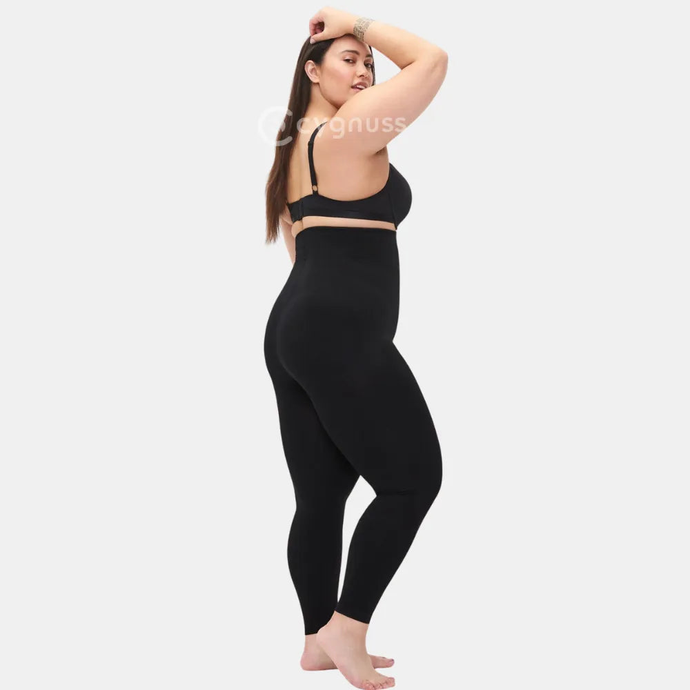 Mulher plus size em pose lateral usando a Legging Jade Fit Modeladora de Cós Alto na cor preta, destacando o ajuste anatômico, a modelagem que valoriza as curvas e o cós alto que proporciona firmeza e conforto.