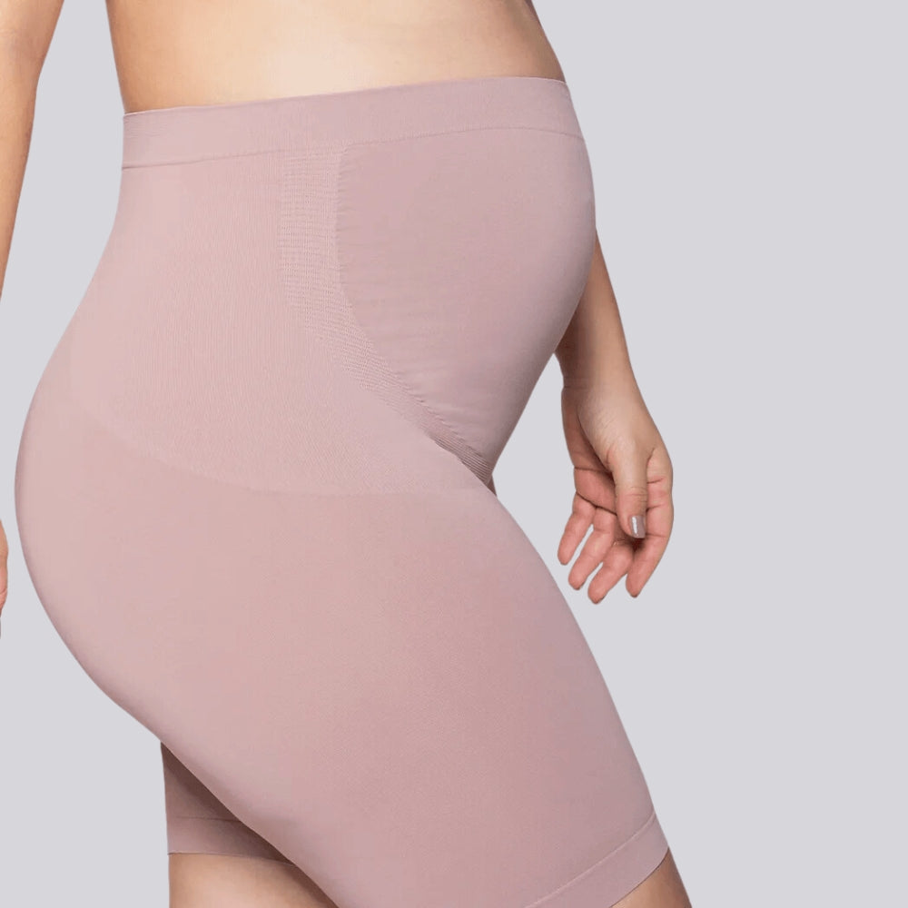 Vista lateral do Short Gestante Microfibra Cygnuss x Lupo na cor rosada, mostrando a sustentação na barriga e a modelagem que se adapta às curvas com conforto.