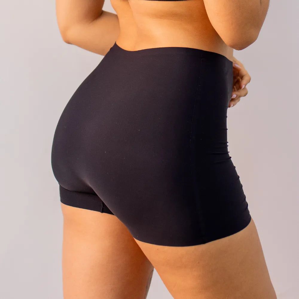 Imagem de um short segunda pele sem costura na cor preta, destacando o modelo de cintura alta e sem costura visível. A peça oferece modelagem e conforto, proporcionando um ajuste perfeito ao corpo.