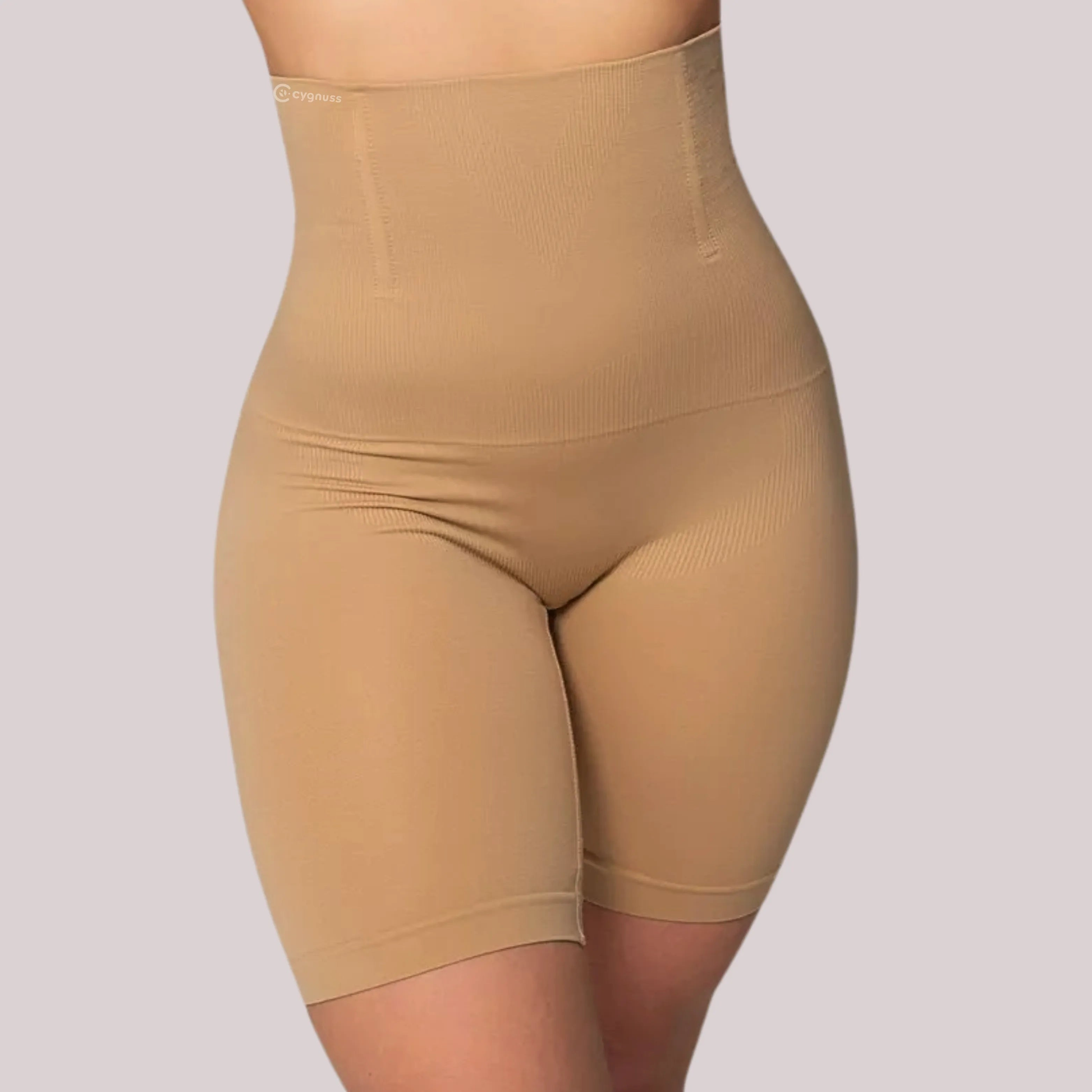 Mulher vestindo o Short Shape modelador da Cygnuss na cor bege, com cintura alta e barbatanas de silicone embutidas, oferecendo compressão na barriga, modelagem do quadril e firmeza nas coxas.