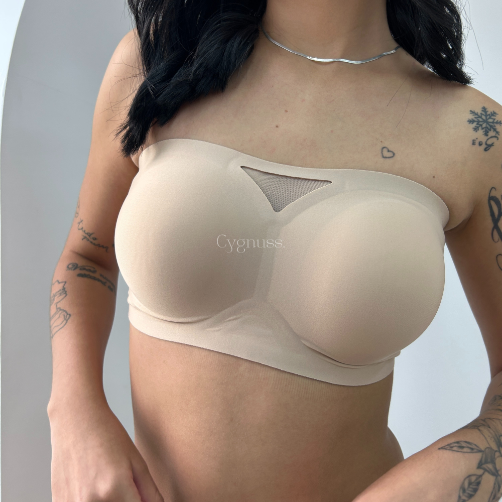 Modelo usando o Sutiã Tomara que Caia Sensação na cor bege, destacando seu design sem alças, bojos estruturados e detalhe em tule no decote. O tecido suave e a modelagem proporcionam conforto e suporte elegante.