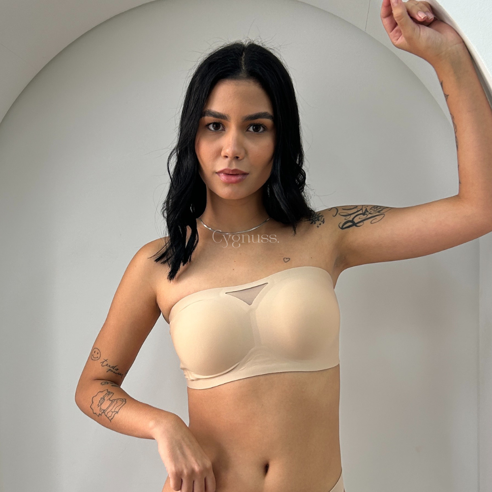 Modelo vestindo o Sutiã Tomara que Caia Sensação na cor bege, destacando o ajuste confortável e a estrutura firme sem alças. O design elegante conta com um detalhe em tule no decote, realçando a modelagem natural dos seios.