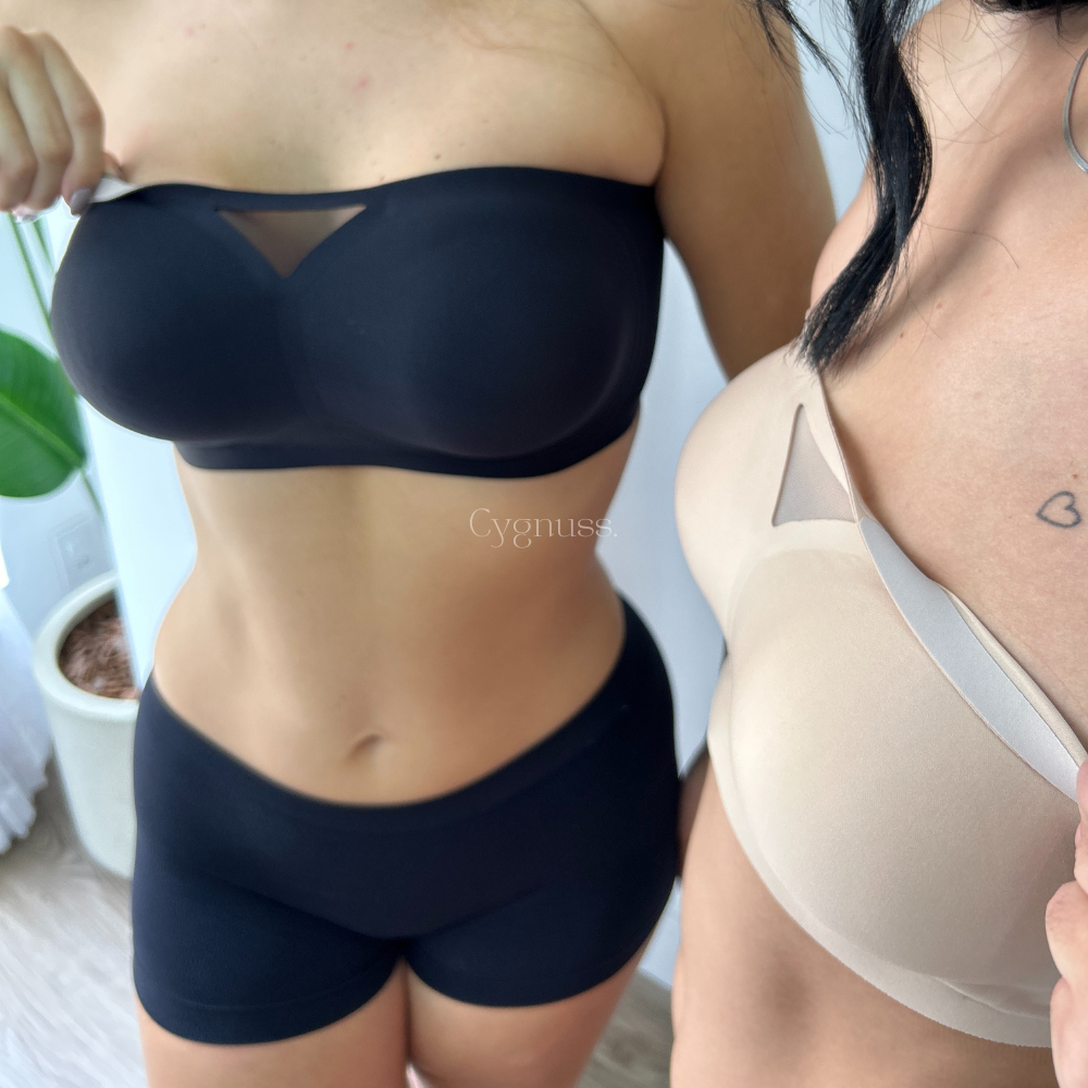 Duas modelos vestindo o Sutiã Tomara que Caia Sensação nas cores preto e bege, destacando a modelagem estruturada e o recorte triangular em tule no centro. A peça oferece sustentação sem alças e um ajuste seguro ao corpo