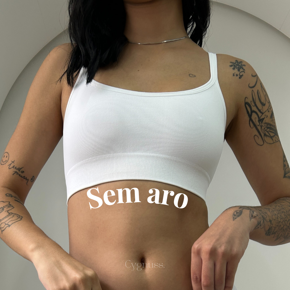 Mulher vestindo o Top Power na cor branca da Cygnuss, destacando o design sem aro para máximo conforto. O modelo sem costuras se ajusta ao corpo com suavidade, enquanto a textura canelada do tecido proporciona um toque moderno. O texto "Sem aro" reforça a leveza e liberdade da peça.