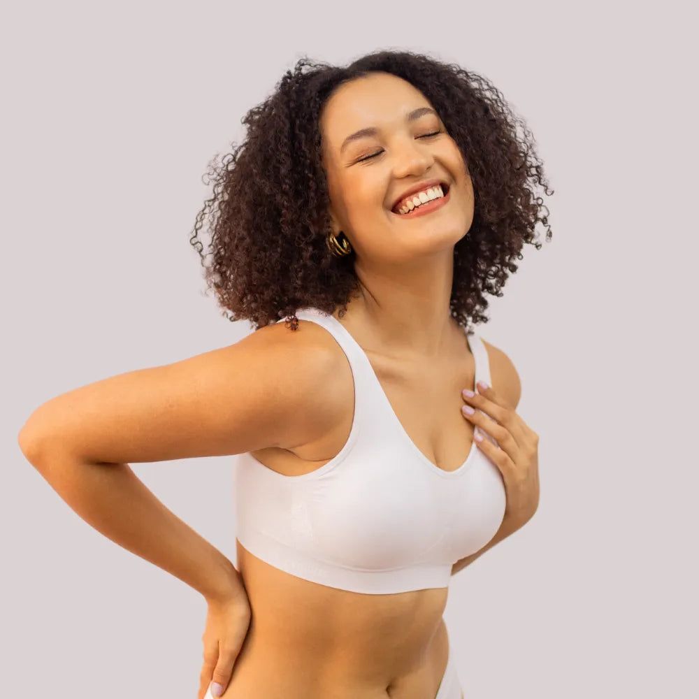 Modelo usando um top bege de modelagem confortável, com alças largas e tecido sem costura.