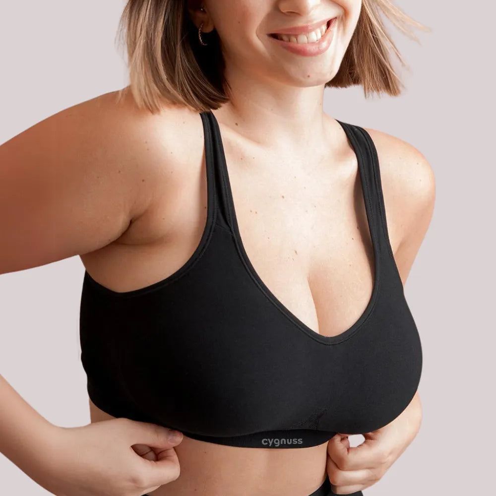 Modelo usando top reforçado preto sem costura, com alças largas e tecido ajustável ao corpo.