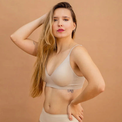 Modelo loira vestindo o Sutiã Alça Fina Cygnuss na cor nude, destacando a modelagem anatômica que realça e sustenta o busto.