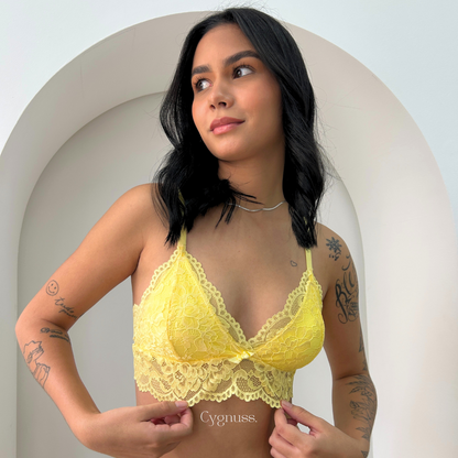 Modelo ajustando o Sutiã Aurora Cygnuss amarelo, destacando o encaixe perfeito e a delicadeza da peça.