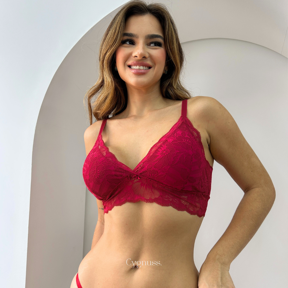 Modelo sorrindo enquanto veste o Sutiã Aurora Cygnuss vermelho, evidenciando o conforto e o charme da peça.