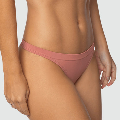 Close frontal da calcinha fio rosé Cygnuss x Lupo, vestida por modelo real. Com laterais médias e acabamento sem costura, a peça em microfibra oferece toque macio, ajuste perfeito e conforto invisível sob a roupa.