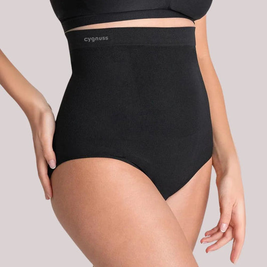 Modelo vestindo a Calcinha Modeladora Juliette preta com faixa de silicone da Cygnuss, peça de cintura alta que modela a silhueta com conforto e qualidade premium.


