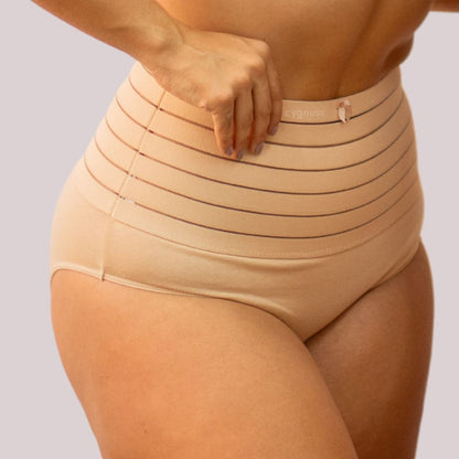 Imagem de mulher usando a Calcinha Modeladora Model - Seca Barriga, em tom bege. A peça de alta compressão tem faixa com listras horizontais, proporcionando controle da barriga e modelagem eficiente da silhueta.