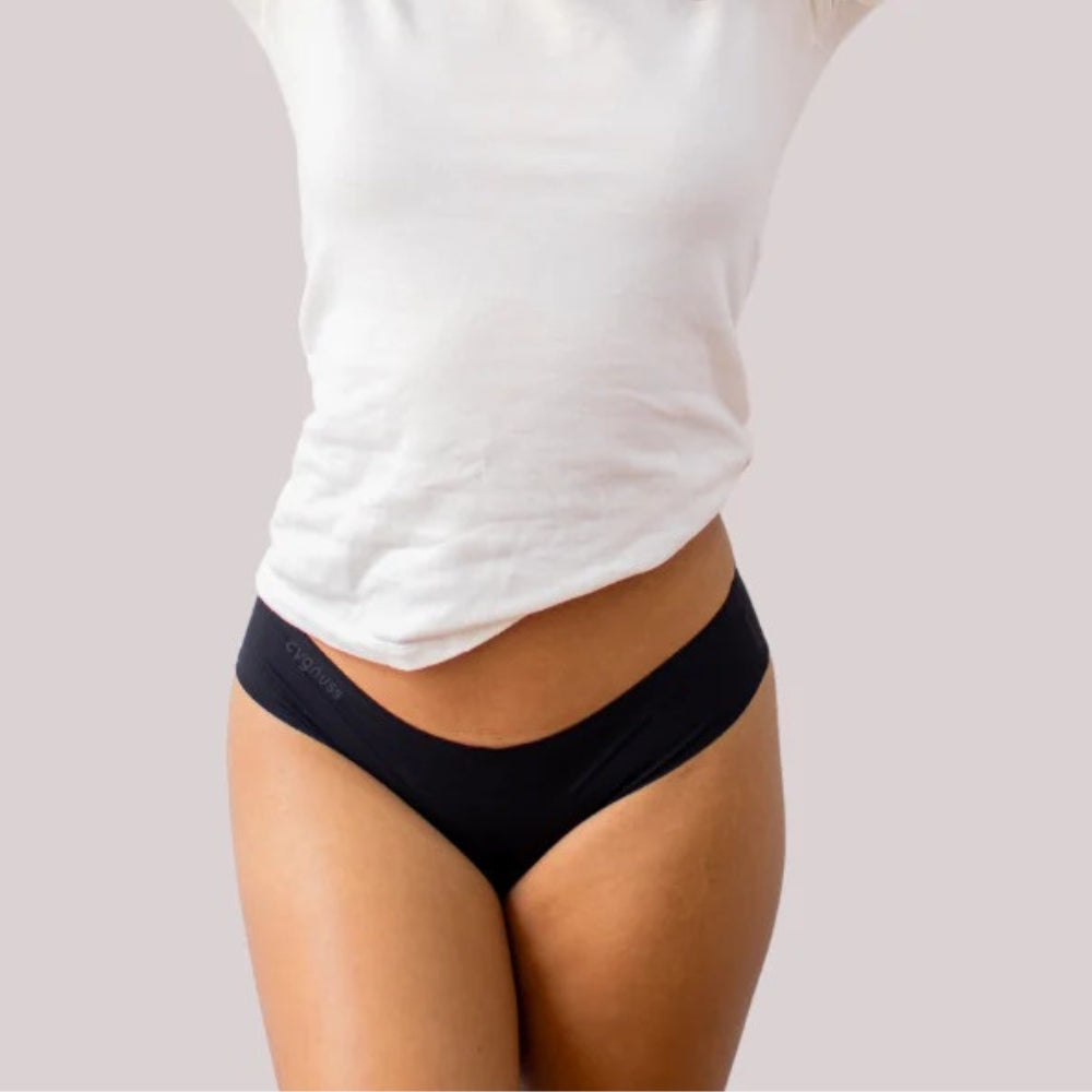 Modelo vestindo calcinha preta sem costura da Cygnuss com camiseta branca, ideal para o dia a dia com conforto e discrição.