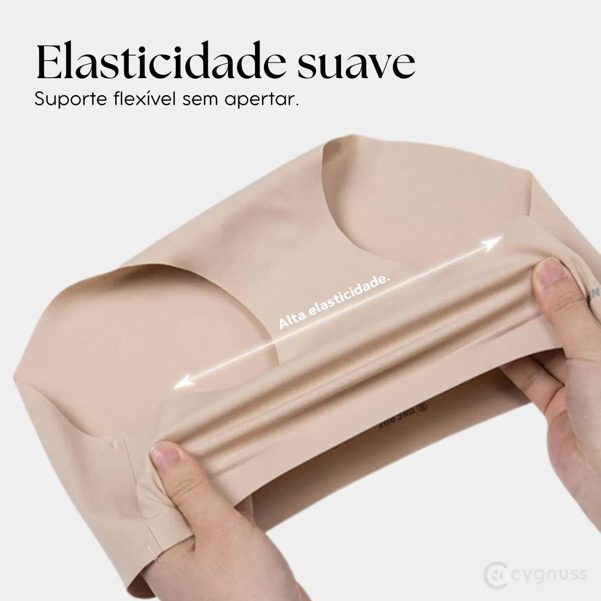 Mãos esticando a Calcinha Soft bege da Cygnuss, evidenciando a alta elasticidade do tecido e o suporte flexível sem apertar, com a frase “Elasticidade suave” em destaque.