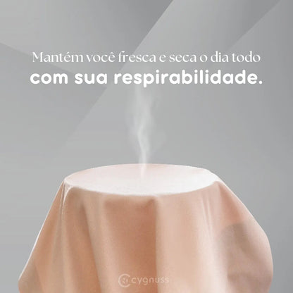 Ilustração da respirabilidade da Calcinha Soft bege da Cygnuss, com tecido estendido liberando vapor e a frase “Mantém você fresca e seca o dia todo com sua respirabilidade” em destaque.