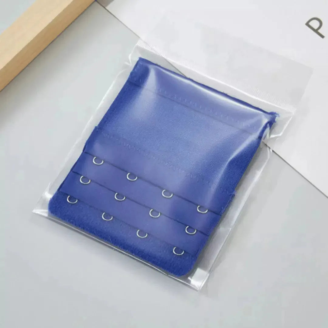 Extensor de sutia azul com tres niveis de ajuste e ganchos metalicos, embalado individualmente em plastico transparente. Ideal para ajustar o sutia com mais conforto e versatilidade no dia a dia. Fundo claro e organizado.