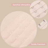 : Close no extensor de sutia Cygnuss destacando os ganchos reforcados e o tecido premium. A imagem apresenta texturas ampliadas em três circulos: estrutura dos ganchos, acabamento do tecido e parte interna com fecho metalico. Fundo bege com textos explicativos.