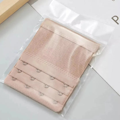 Extensor de sutia rose com tres niveis de ajuste e ganchos reforcados, embalado individualmente em plastico transparente. Acessorio ideal para ampliar o conforto e a adaptabilidade do sutia ao corpo. Fundo claro com visual organizado.