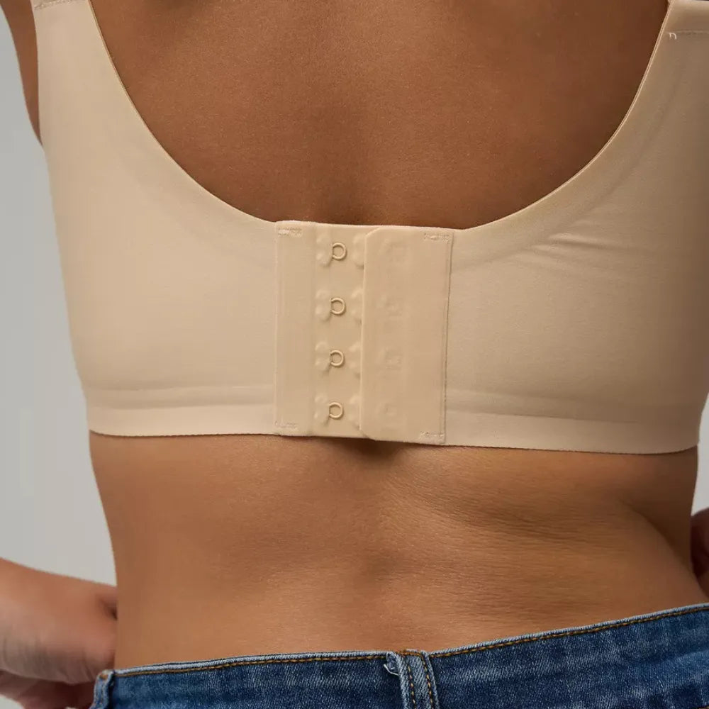 Detalhe das costas do sutiã Compress bege com fecho ajustável, compõe o kit de conforto e sustentação ideal.