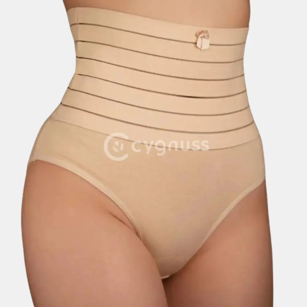 Imagem de uma mulher usando uma cinta modeladora bege com faixas de compressão horizontais. A cinta está posicionada na região abdominal, proporcionando um efeito de modelagem. O produto é de cor neutra e combina com a lingerie de cintura alta, com o logo da marca Cygnuss visível na parte inferior.

