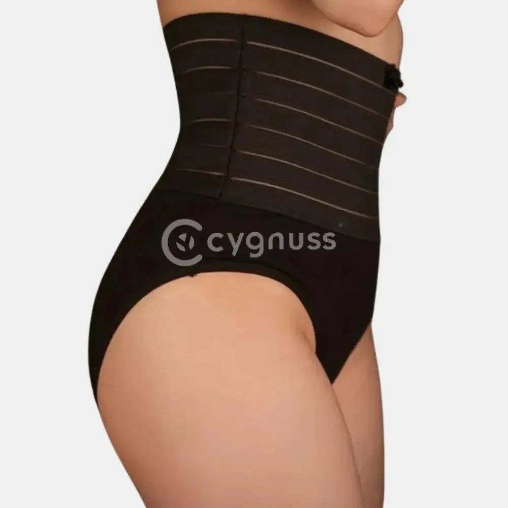 Imagem de uma mulher usando uma cinta modeladora preta com faixas de compressão. A cinta tem detalhes em linhas horizontais e a mulher a está usando com um short preto. O foco está na área da cintura, mostrando como a cinta modela e define a silhueta.