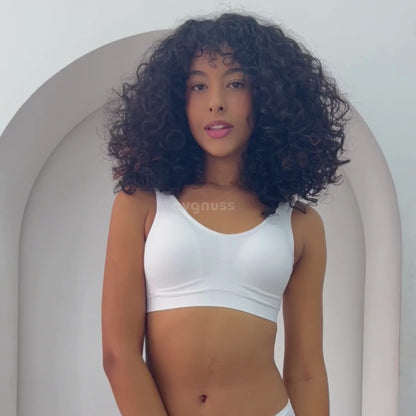 Modelo usando um top branco de modelagem confortável, com alças largas e tecido sem costura.
