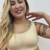 Mulher vestindo um sutiã premium bege Cygnuss com alças largas, oferecendo conforto, suporte e modelagem sem costuras para um ajuste perfeito.