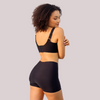  mulher usando o Short Segunda Pele Sem Costura na cor preta. A peça proporciona conforto e modelagem sem costuras, garantindo um ajuste perfeito e discreto para o dia a dia, com o logo da Cygnuss visível na parte superior.