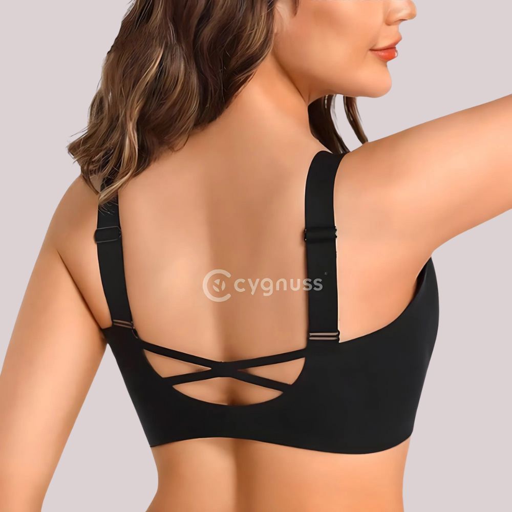 Mulher de costas vestindo o Sutiã Academy na cor preta, destacando as alças ajustáveis e o design cruzado nas costas, que proporciona maior sustentação e estilo. O tecido sem costuras garante conforto e ajuste perfeito ao corpo. O logo da Cygnuss está visível no centro da imagem.