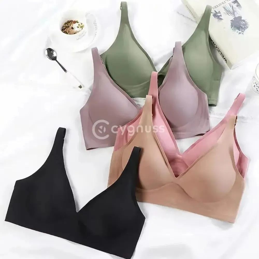 : Conjunto de Sutiãs FIT exibidos sobre uma superfície clara, nas cores preto, rosé, bege, verde oliva e lilás acinzentado. Todos os modelos possuem alças finas, bojo removível e acabamento sem costura, destacando a variedade de tons neutros e elegantes disponíveis.