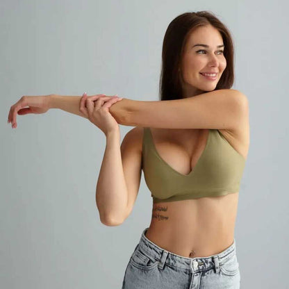 Mulher sorrindo enquanto alonga o braço, vestindo o Sutiã FIT verde oliva. O modelo possui alças finas, bojo removível e decote profundo, com acabamento sem costuras que valoriza o busto e garante conforto em movimentos do dia a dia.

Se quiser que eu monte uma legenda para post ou descrição de produto no site com base nessa imagem, só dizer!
