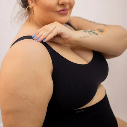 Mulher plus size usando sutiã preto Cygnuss com alças largas e tecido sem costura, destacando conforto e sustentação para todos os tipos de corpo.