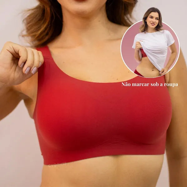 Mulher usando sutiã vermelho Cygnuss sem costura visível; destaque mostra como o sutiã não marca sob roupas claras, ideal para conforto e discrição.