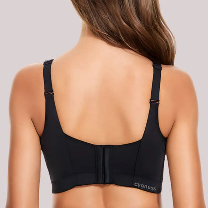 Mulher vista de costas vestindo o Sutiã ElevaTop – Super Sustentação push up da Cygnuss na cor preta. A imagem mostra as alças largas reguláveis e o fecho traseiro reforçado com múltiplos colchetes. O logo "cygnuss" aparece na lateral inferior da peça.