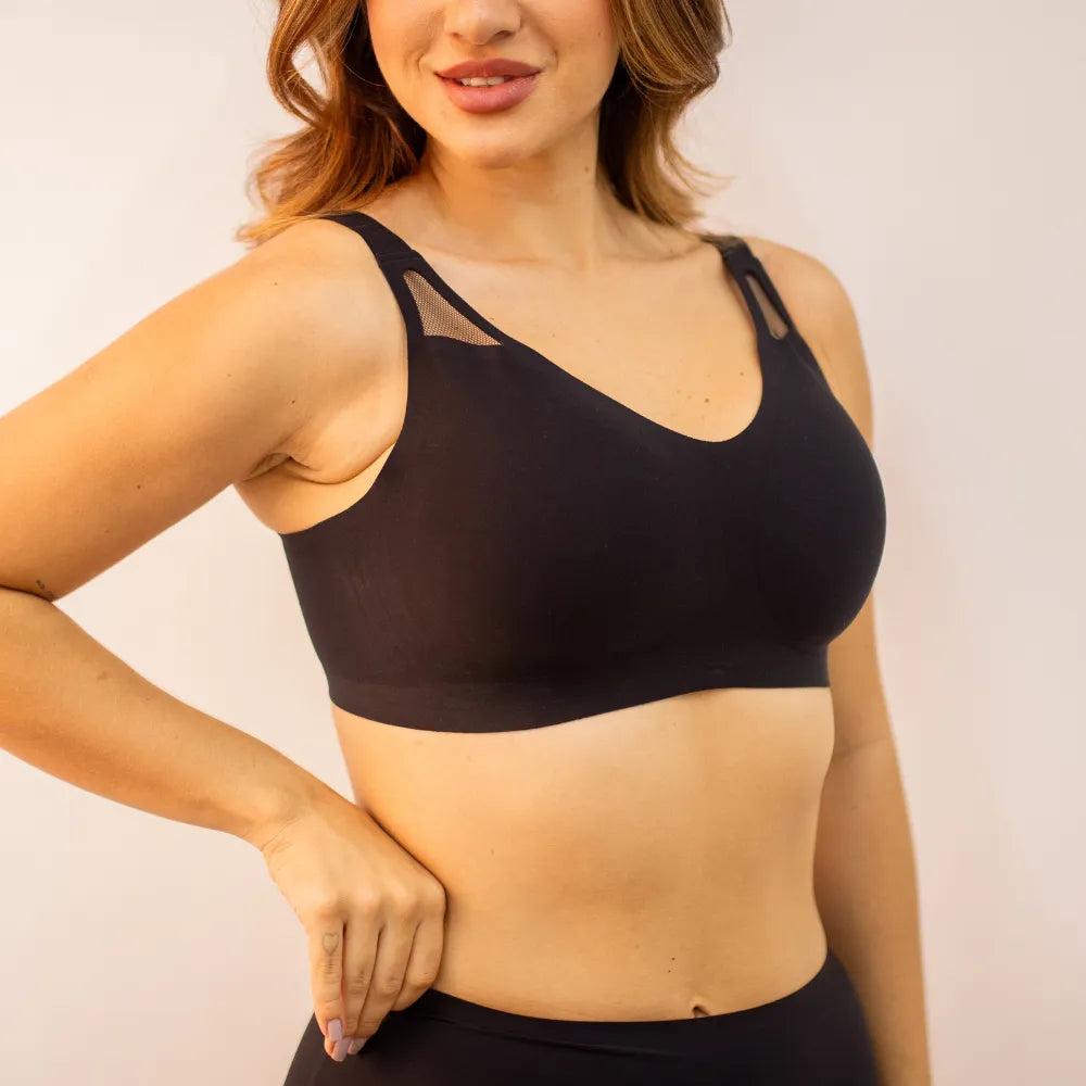 Modelo usando sutia esportivo preto da Cygnuss com detalhe em tule nas alças e tecido sem costura, ideal para oferecer sustentação com conforto no dia a dia.