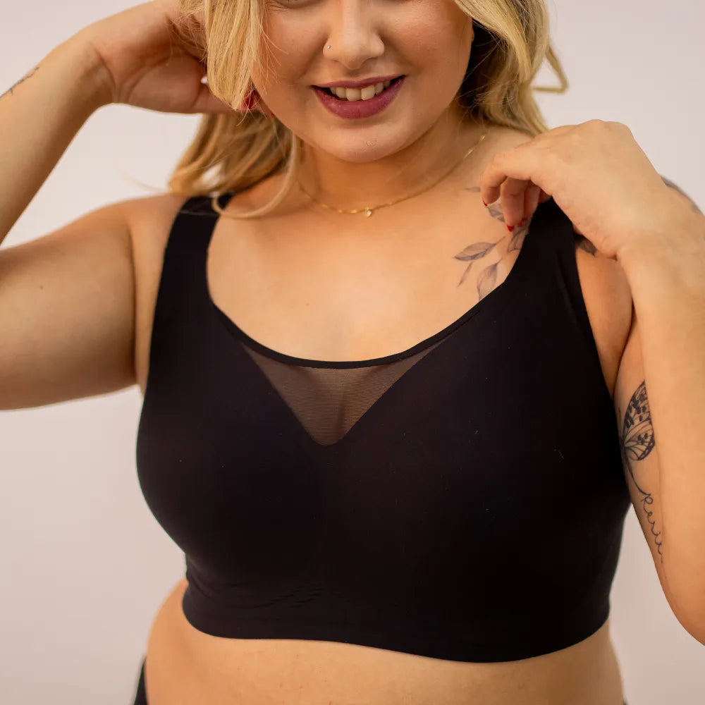 Mulher usando sutiã modelador preto com transparência no decote, peça confortável ideal para o dia a dia no kit promocional com sustentação para todos os tamanhos.