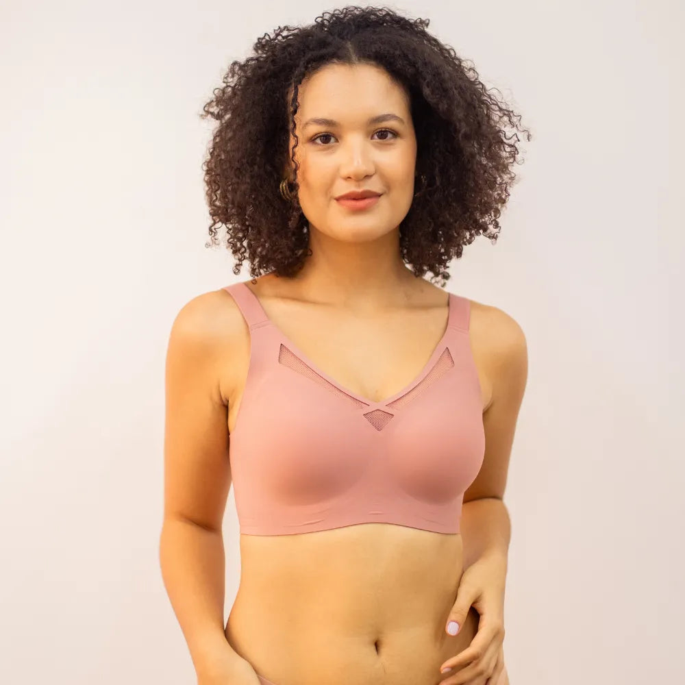Modelo vestindo sutiã rosado com detalhe em tule no decote, peça que faz parte do kit em promoção com conforto e sustentação para o dia a dia.
