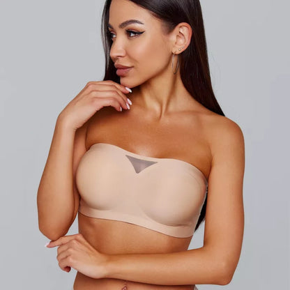 Modelo usando sutiã tomara que caia bege da Cygnuss com detalhe em tule no centro, olhando para o lado com pose elegante e acabamento sem costura.