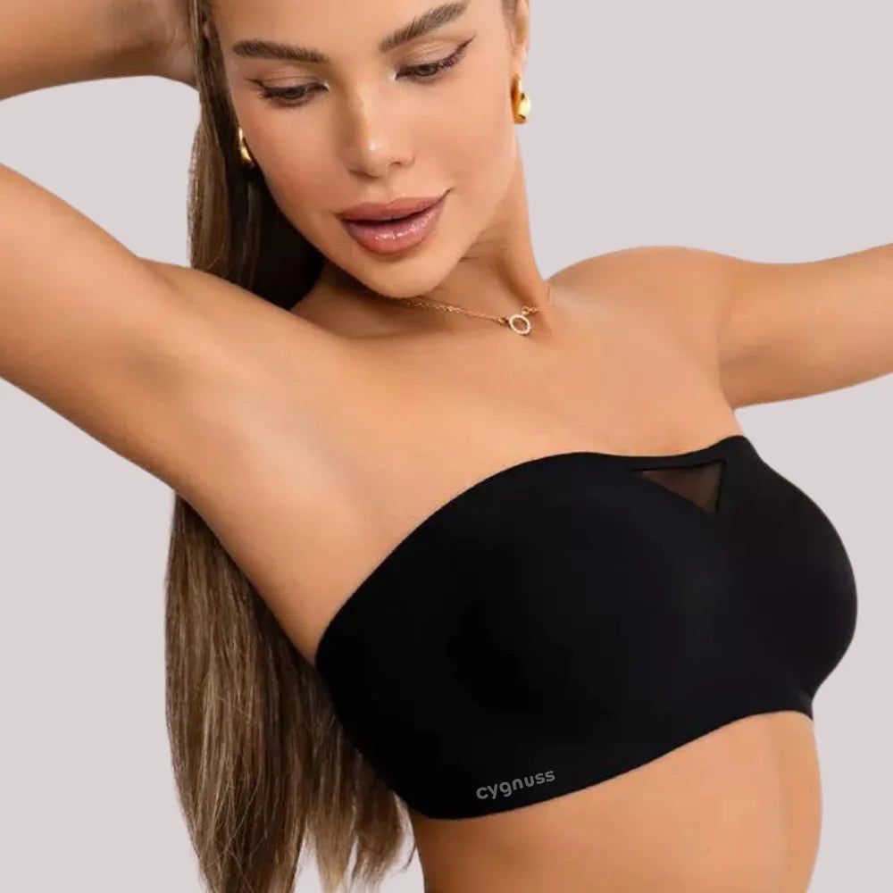Modelo usando sutiã tomara que caia preto da Cygnuss com detalhe em tule, vista lateral com braço levantado e expressão sorridente.
