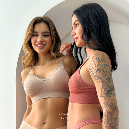 Duas mulheres usando o Sutiã Trend Curves Cygnuss x Lupo, uma na cor bege e a outra na cor terracota, sorrindo e interagindo em um ambiente claro, destacando o caimento natural, conforto e estilo da peça.

