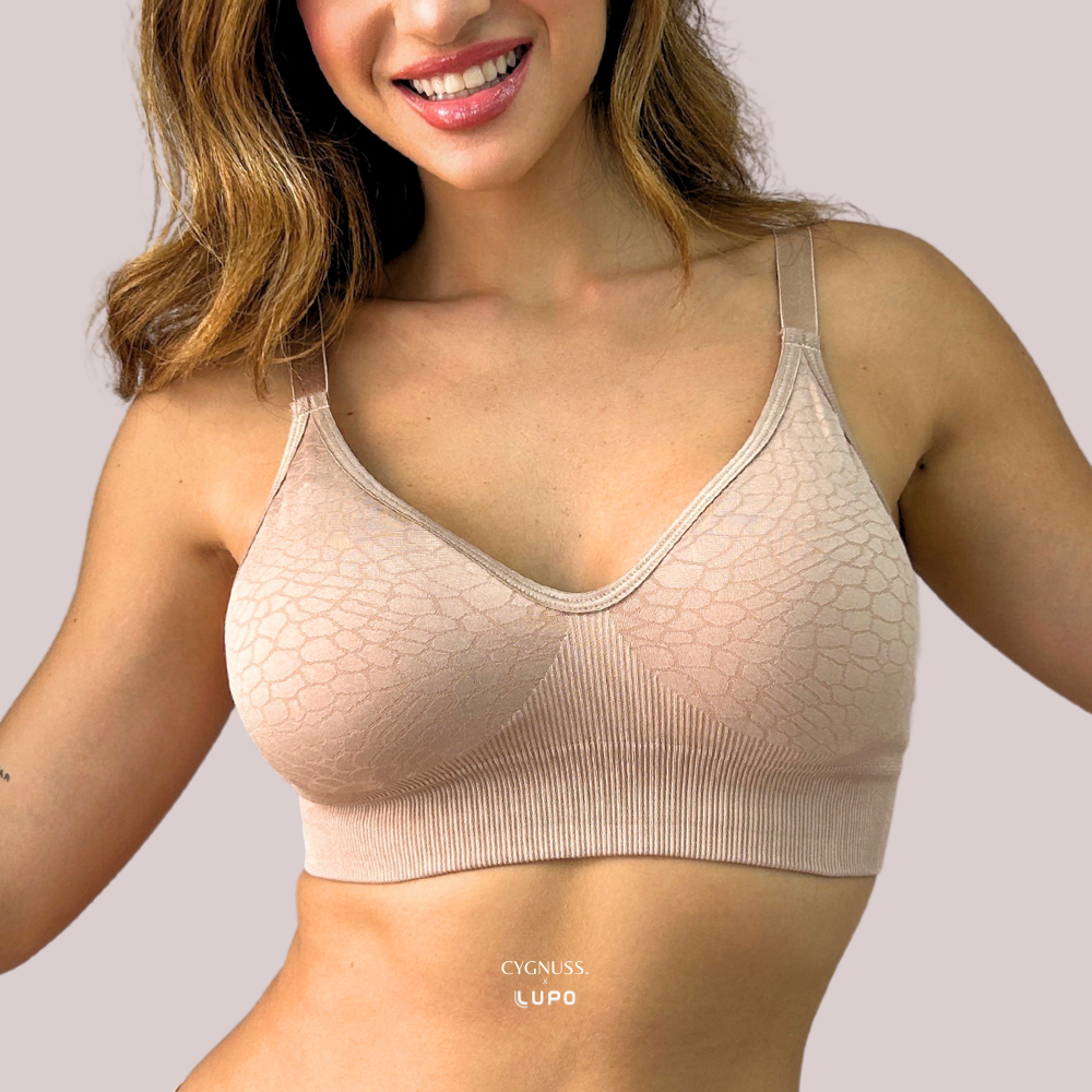 Mulher sorridente usando o Sutiã Trend Curves Cygnuss x Lupo na cor bege, exibindo a modelagem confortável sem aro, estampa em relevo elegante e alças finas ajustáveis.