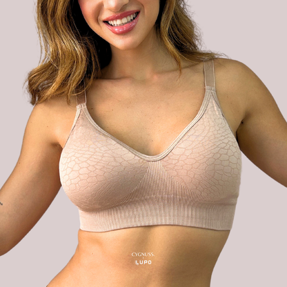 Mulher sorridente usando o Sutiã Trend Curves Cygnuss x Lupo na cor bege, exibindo a modelagem confortável sem aro, estampa em relevo elegante e alças finas ajustáveis.