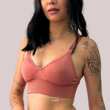Mulher com tatuagens usando o Sutiã Trend Curves Cygnuss x Lupo na cor terracota, mostrando a textura em relevo, alças largas e o design confortável sem aro.